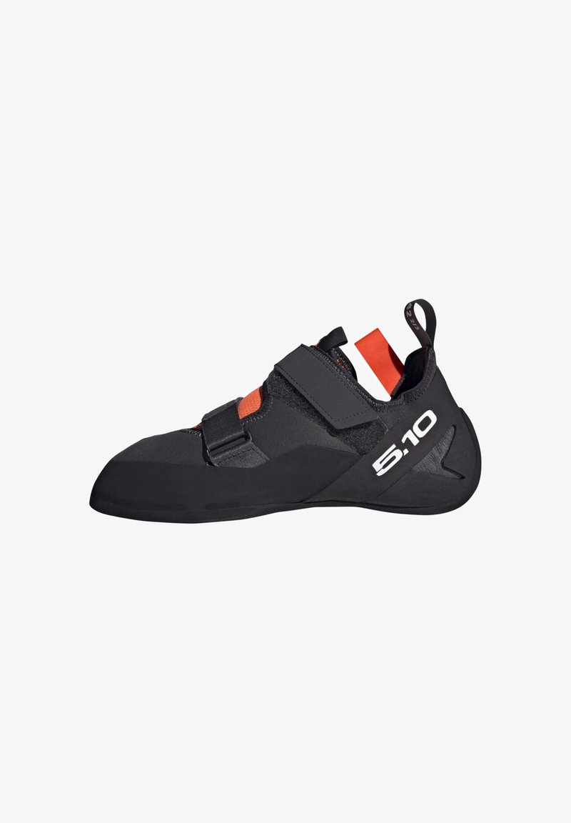 Kletterschuh aus einem eleganten schwarzen synthetischen Material, mit Gummisohle, verstellbaren Riemen und einem markanten roten Akzent an der Ferse.