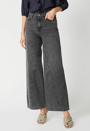 Wide-leg black denim jeans featuring a high waist and side pockets, complemented by a subtle textured finish.