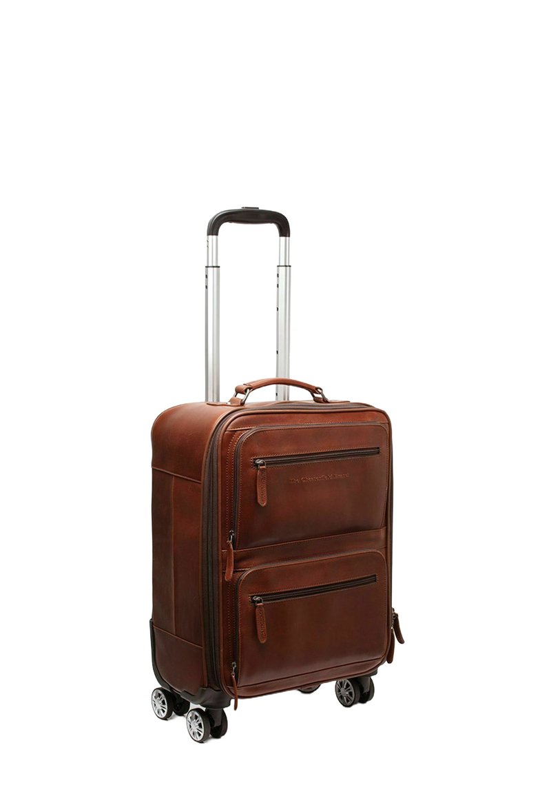 Maleta rodante de cuero marrón con herrajes plateados, dos bolsillos frontales con cremallera y cuatro ruedas giratorias. El mango telescópico se extiende.