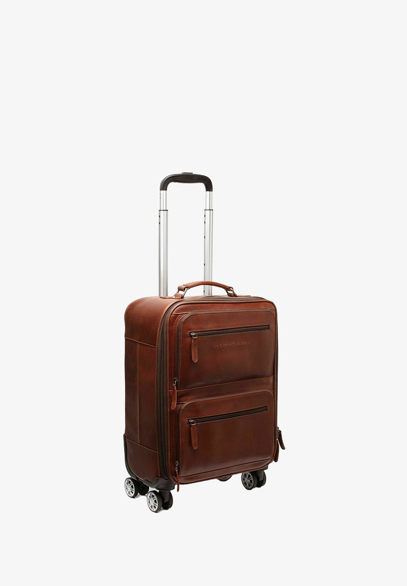 Maleta rodante de cuero marrón con herrajes plateados, dos bolsillos frontales con cremallera y cuatro ruedas giratorias. El mango telescópico se extiende.