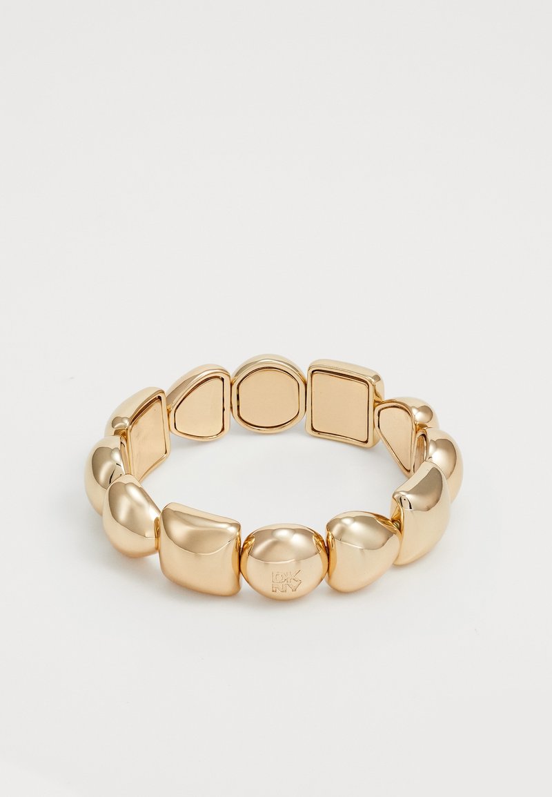 Bracelet ton or avec des formes géométriques lisses alternées, comprenant des cercles, des carrés et des triangles arrondis, disposés sur une bande extensible.