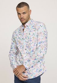Chemise à boutons florale dans des couleurs pastel, avec un fond clair et des motifs bleus, roses et verts, à manches longues et col structuré.