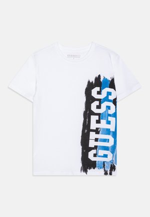 Weißes T-Shirt mit kurzen Ärmeln, vertikalem schwarz-blauem Pinselstrich-Design und GUESS-Logo in fetten weißen Buchstaben auf der rechten Seite.
