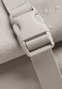 Sangle imperméable beige en tissu texturé, présentant une boucle en plastique durable ornée de gouttes d'eau.