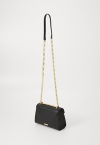 Borsa a mano in pelle nera con un motivo texturizzato, caratterizzata da una tracolla in catena dorata e una maniglia superiore liscia. Forma compatta e rettangolare.