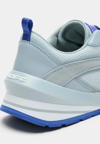 Baskets bleu clair avec une tige en mesh, des accents en daim gris, et une semelle épaisse blanche et bleue avec une légère texture et des coutures visibles.