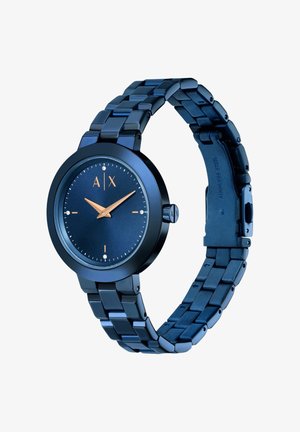 Reloj de acero inoxidable azul con esfera redonda, diseño minimalista, marcadores en números árabes y acentos en oro rosa en las manecillas y el logotipo.