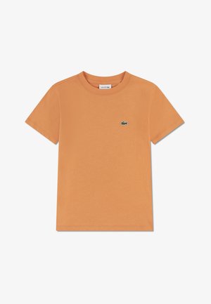 Oranje katoenen T-shirt met korte mouwen, ronde hals en een klein groen Lacoste-logo geborduurd op de linkerborst. Gladde textuur.