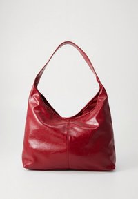 Sac hobo en cuir rouge avec une texture lisse, une bandoulière unique, une forme arrondie et des détails de coutures discrètes.