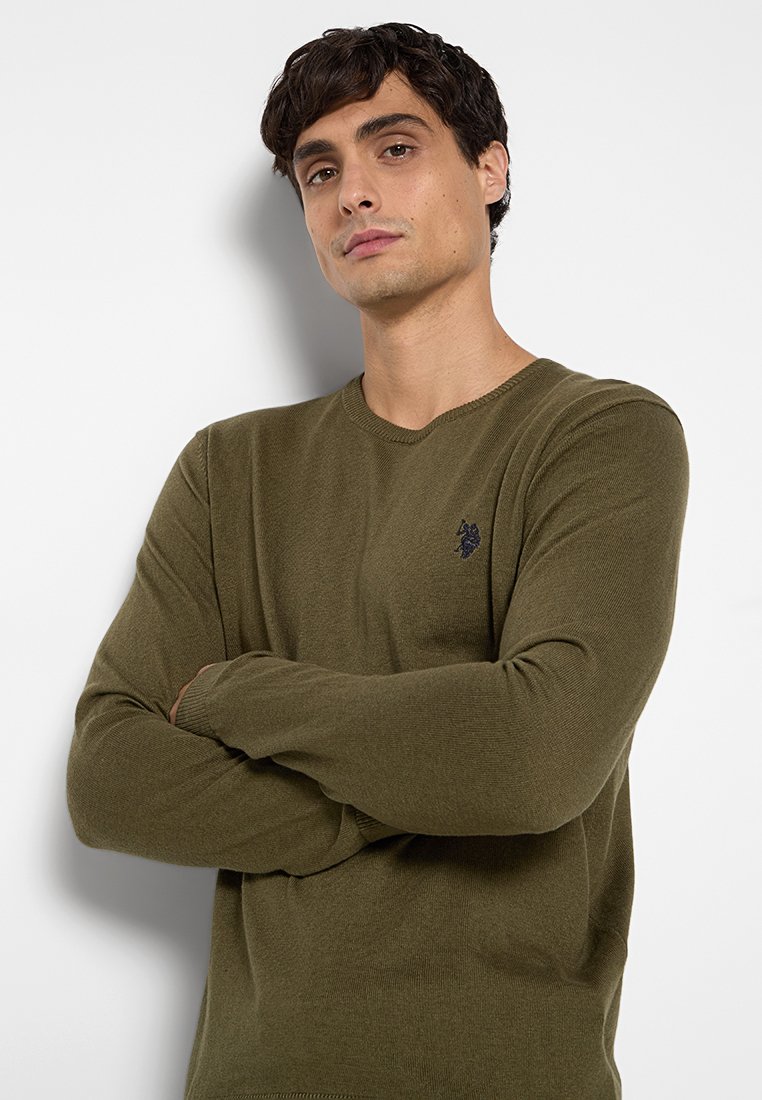 Maglione lavorato a maglia verde oliva a maniche lunghe con scollatura rotonda e finitura testurizzata; presenta un piccolo logo scuro sul petto.