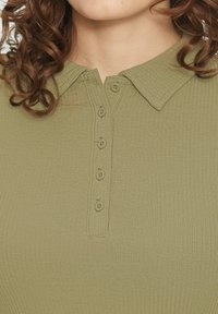 Kraag knoopshirt in olijfgroen, met een geribbelde textuur en zes bijpassende knopen langs de sluiting.