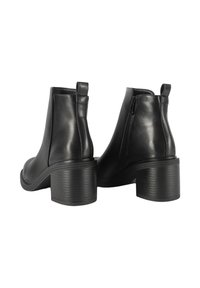 Stivali alla caviglia neri in pelle con punta rotonda, pannelli elastici laterali e tacco a blocco texturizzato. Presentano un'etichetta posteriore per il tallone e una chiusura con zip.