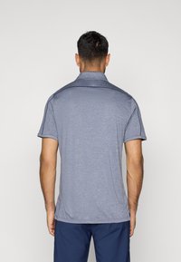 Ανδρικό πόλο μπλούζα σε μαλακό, υφασμένο σκούρο μπλε ύφασμα. Διαθέτει γιακά και κοντά μανίκια, με αντίθεση στις λεπτομέρειες στους ώμους.