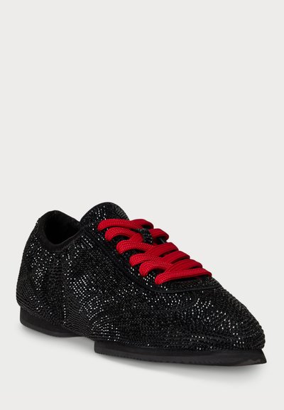 Sneaker nera con texture, superficie scintillante, lacci rossi e suola in gomma. Presenta una punta arrotondata e un design a profilo basso.