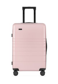 Valigia rigida rosa con superficie texturizzata, scanalature verticali, manico nero estensibile e quattro ruote per la mobilità.