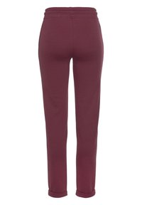 Bordeauxfarbene Jogginghosen mit elastischem Bund, tailliertem Beinbereich, glatter Textur und umgeschlagenem Saum am Knöchel.