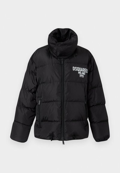 Doudoune noire avec col haut, fermeture éclair, deux poches latérales, et logo blanc "DSQUARED2 MILANO 1995" sur la poitrine. Texture lisse et brillante.