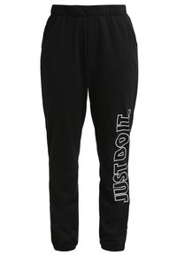 Zwarte trainingsbroek met een elastische tailleband, zijzakken en een witte "JUST DO IT." logo verticaal gedrukt op het linkerbeen.