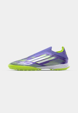 Purple soccer cleat with a sleek design, featuring green accents, textured upper, prominent stripes, and a traction-focused sole.
