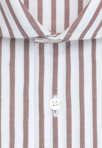 Chemise blanche à rayures verticales marron, gros plan sur le col et la zone des boutons, montrant la texture du tissu et les détails des coutures.
