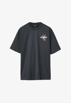 Zwart katoenen T-shirt met korte mouwen, voorzien van een bloemmotief en tekstontwerp op de borst. Ronde halslijn, losse pasvorm.