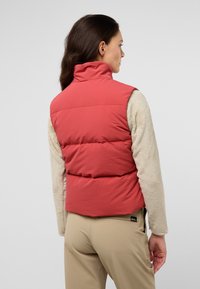 Rode gewatteerde puffervest met een hoge kraag en beige fleece mouwen, met een gladde textuur en een contrast in materialen.