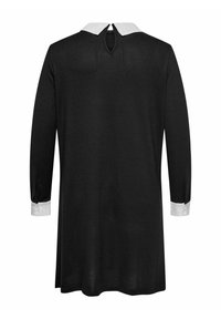 Crna haljina dugih rukava s bijelim manžetama i bijelim ovratnikom. Ima otvor s ključem na leđima. Glatka tekstura, opušteni kroj.