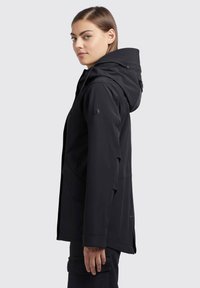 Svart vattentät jacka med huva, texturerad inredning och zip-fickor. Designen är funktionell med en minimalistisk stil.