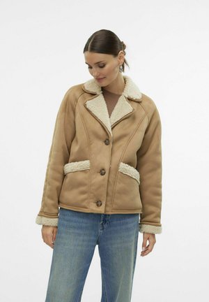 Braune Kunstlederjacke mit cremefarbenem Kunstfellkragen und -manschetten, mit Knopfverschluss und Seitentaschen. Strukturiertes Material, warmes Design.