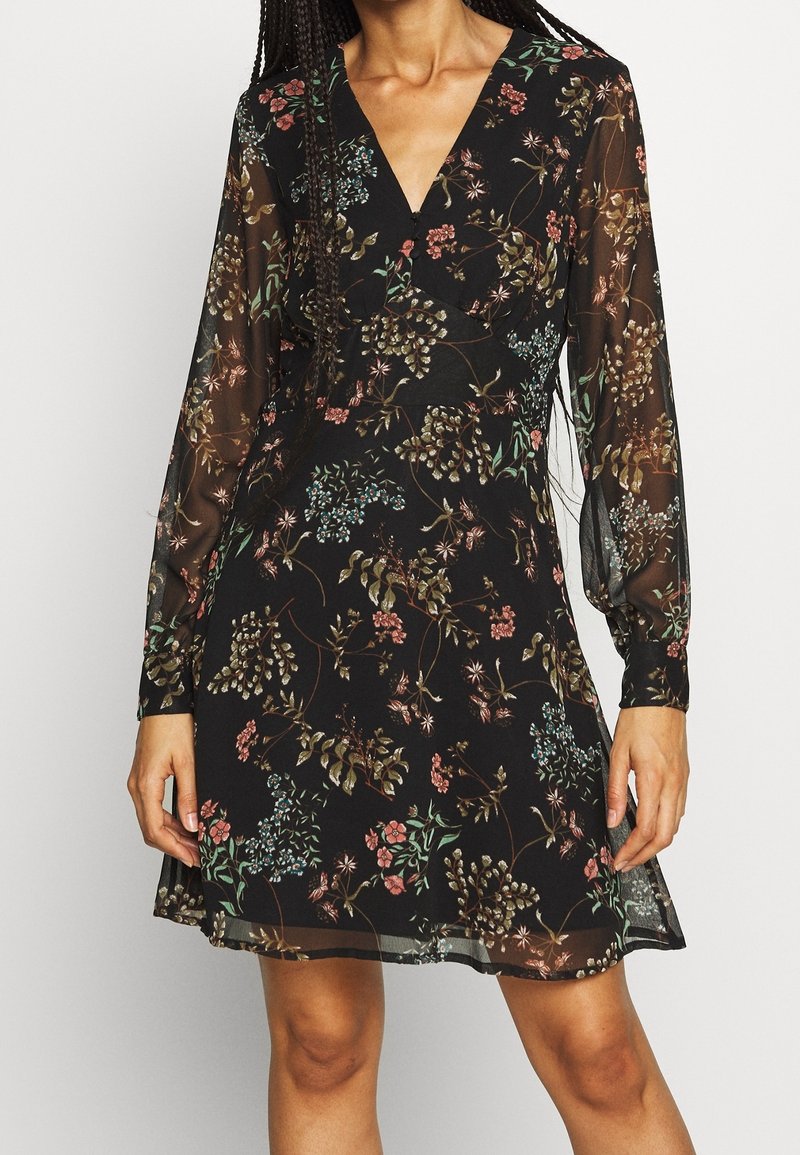 Schwarzes Blumenkleid mit V-Ausschnitt, langen transparenten Ärmeln, verziert mit einem Muster aus bunten Pflanzen und Blumen, strukturiertem Stoff, in der Länge oberhalb des Knies.