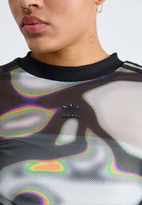 Black mesh top with iridescent wave patterns, a ribbed crew neck, and a small black Adidas logo on the chest. Features visible stitching.