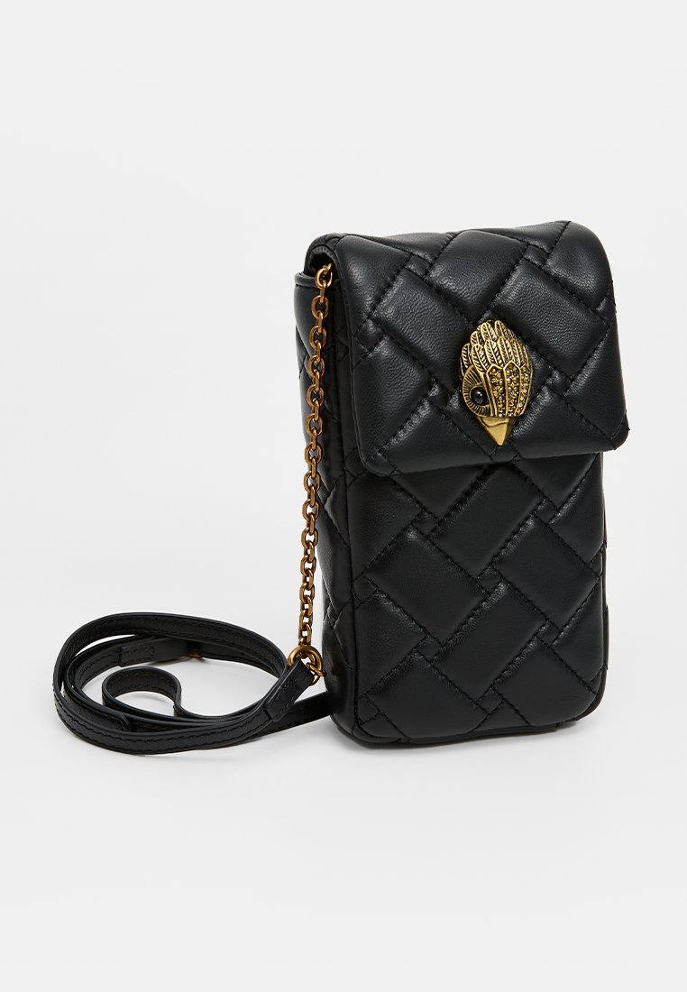 Bolso bandolera de piel sintética negro con acolchado, cierre de solapa y herrajes dorados, que presenta un detalle decorativo de mano y correa de cadena ajustable.