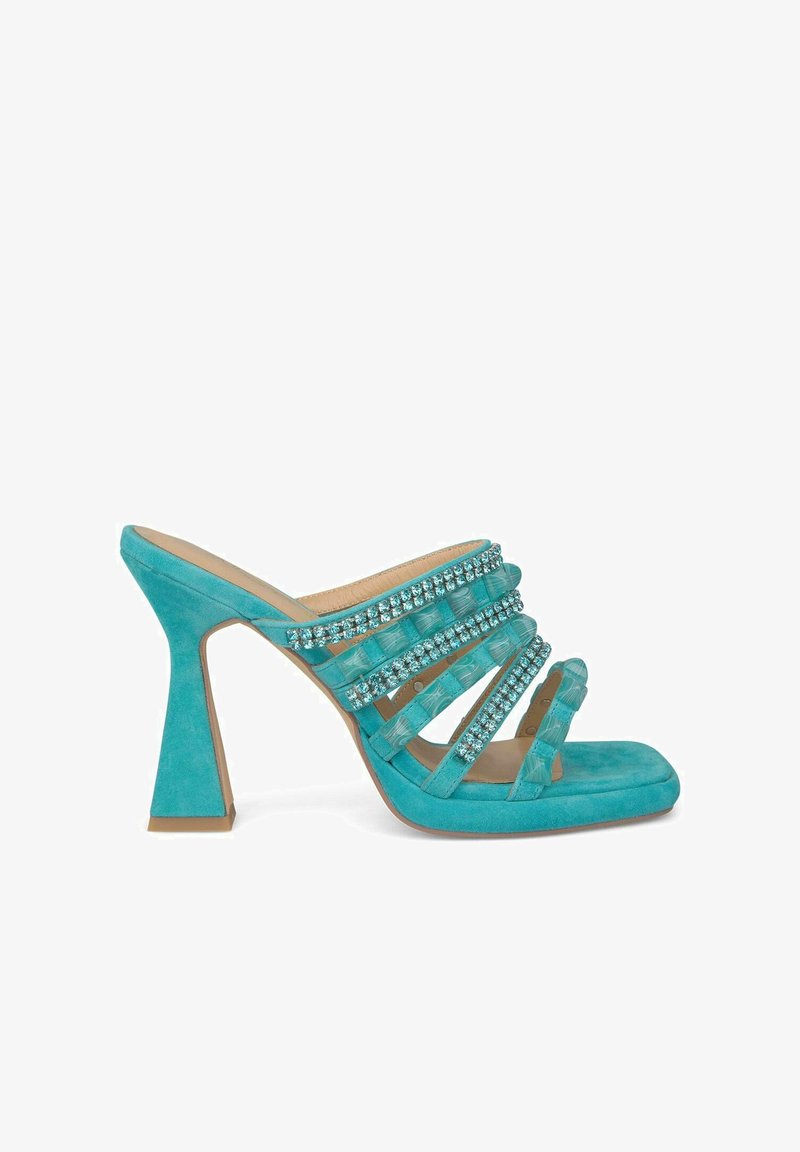 Turquoise suède sandalen met hak, voorzien van meerdere doorzichtige banden versierd met blauwe rhinestones. Heeft een chunky hak en een open teen ontwerp.