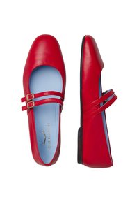 Ballerines en cuir rouge avec deux sangles à boucle, bout rond et intérieur bleu. Elles disposent d'un talon plat et d'une texture de surface lisse.