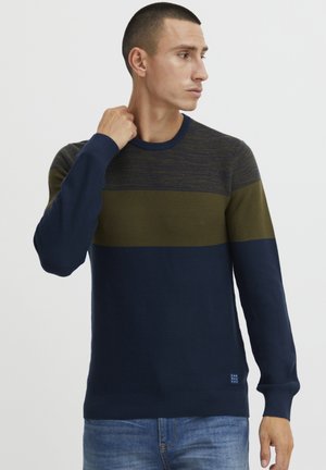 Navyblauw gebreid trui met groene horizontale streep. Ronde hals, geribbelde mouwen en zoom. Bevat een gestructureerd materiaal en een klein logo-detail onderaan.