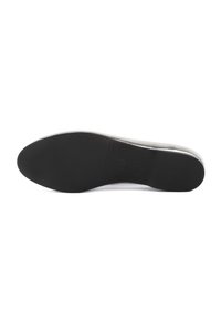 Semelle d'une chaussure habillée noire avec une semelle en caoutchouc lisse, légèrement texturée et un talon bas, vue de côté sur fond blanc.