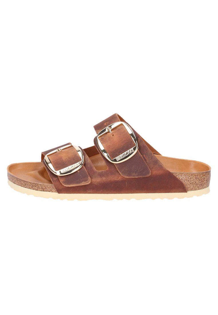 Bruine leren sandalen met twee brede banden, voorzien van zilveren gespen. Kurken voetbed met een beige rubberen zool. Glad textuur en open ontwerp.