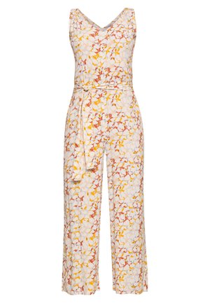 Combinaison fleurie blanche, avec un décolleté en V, sans manches, taille ceinturée et jambes larges ornées de motifs jaunes, rouges et verts.