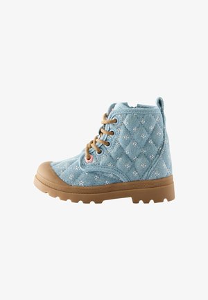 Bottine à la cheville en tissu matelassé bleu clair avec petits motifs floraux blancs, lacets marron et semelle ainsi que bout en caoutchouc marron.