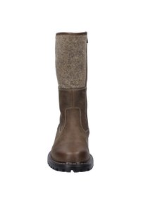 Botas de cuero marrón con parte superior de fieltro. Presentan costuras en contraste y una suela de goma con dibujo. Altura hasta media pantorrilla, diseño robusto.