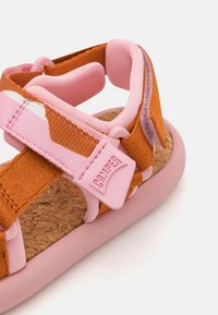 Braune und rosa Sandale mit verstellbaren Riemen, Korkfußbett und Gummisohle. Mit einem Etikett mit dem "Camper"-Logo und weichen, gepolsterten Akzenten.