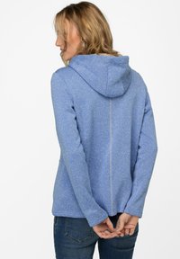 Blåmelerad hoodie med dragsko på huvan, långa ärmar och rak nederkant. Har en vertikal söm längs ryggen.