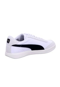 White low-top sneaker with black side stripe, lace-up design, padded collar, and branded logo on heel tab.