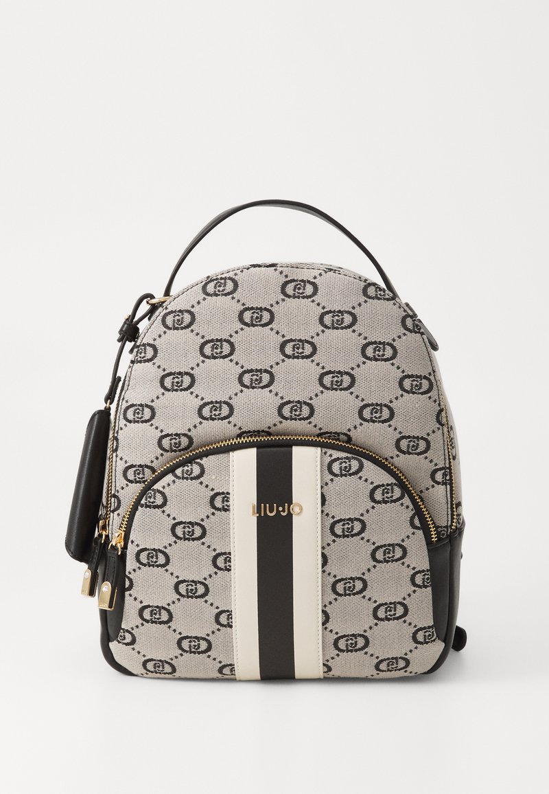 Mochila em tela texturizada na cor bege com padrão de logotipo preto, apresentando uma forma arredondada, fechos duplos e uma faixa preta com marcas em dourado.