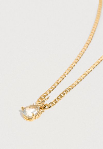 Κολιέ με χρυσή αλυσίδα που διαθέτει ένα διάφανο μενταγιόν σε σχήμα σταγόνας, στερεωμένο σε περίτεχνο μεταλλικό πλαίσιο. Η αλυσίδα έχει κομψό, γυαλιστερό φινίρισμα.