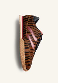 Sneaker con un motivo a strisce di tigre marrone e nero, materiale scamosciato, dettagli rosa, suola in gomma e particolari neri sul tallone e sui lacci.