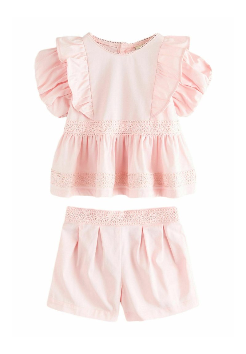 Ensemble deux pièces rose comprenant un haut à manches courtes avec volants et bord en dentelle, ainsi que des shorts assortis à la conception plissée et une taille en dentelle.