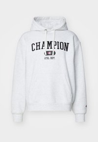 Svetlošedá mikina s kapucňou a predným vreckom, nastaviteľná kapucňa so šnúrkou a čierny grafický nápis "CHAMPION ATHL. DEPT." na hrudi. Mäkko príjemný povrch.