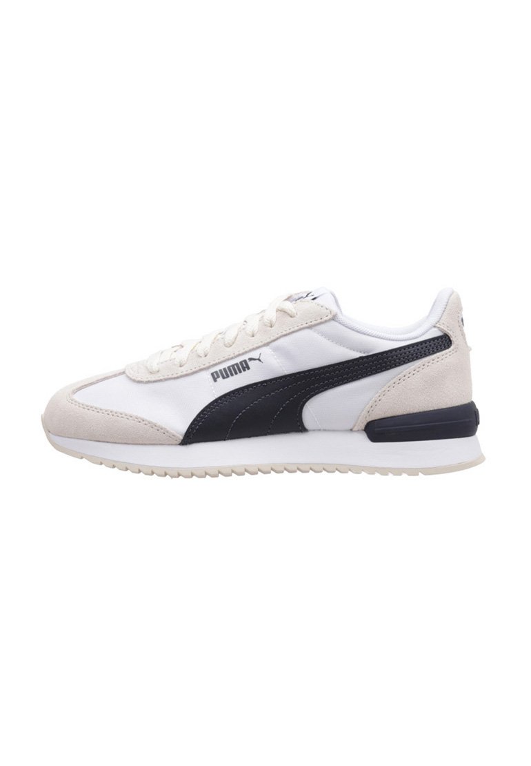 Zapatillas deportivas en blanco y azul marino, con materiales de gamuza y textil, que cuentan con una suela texturizada, punta redondeada y cordones. Logo de Puma visible.