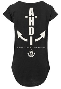 Black short-sleeve t-shirt featuring white text "AHOI" with arrows, and graphics of an anchor and a silhouette, branded "Knut & Jan | Hamburg."